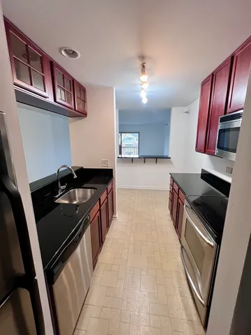 a kitchen with wooden cabinets and a stove top oven