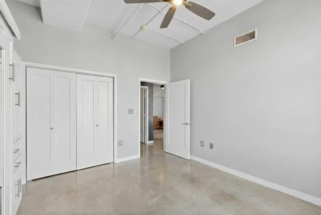 an empty room with a ceiling fan and entryway