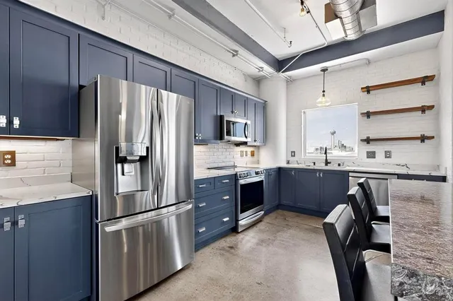 a kitchen with stainless steel appliances sink a refrigerator and cabinets
