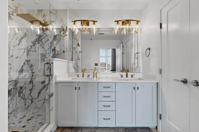 a bathroom with a double vanity sink mirror and shower