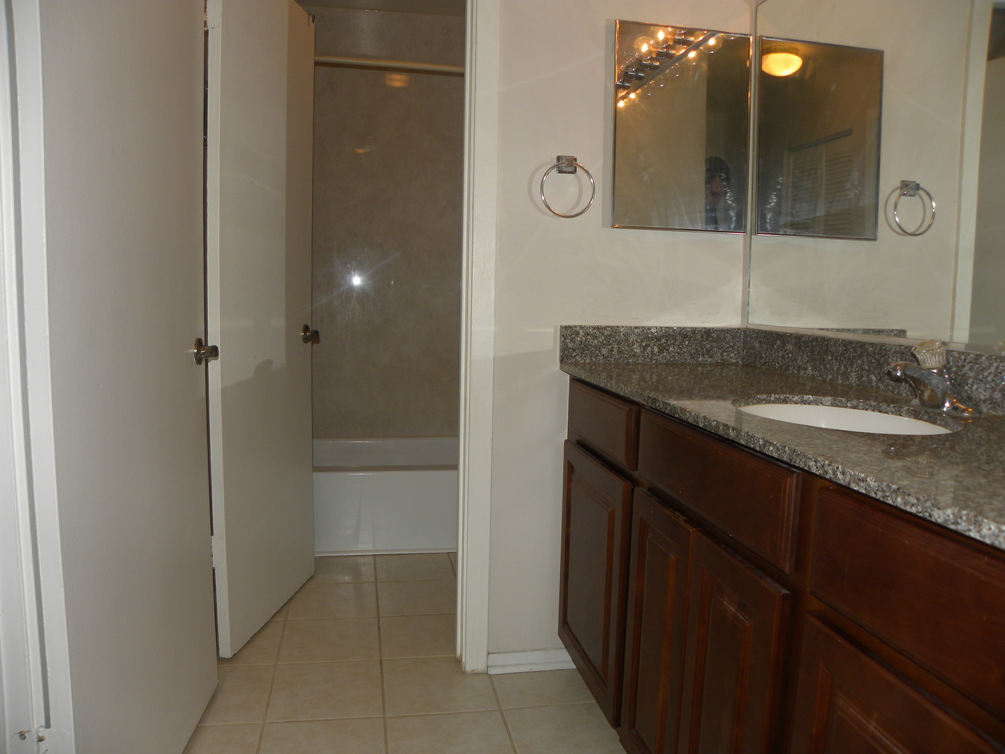 1931 Prairie Square, Unit 308 Schaumburg, IL 60173 - Photo 10 of 11 a bathroom with a granite countertop sink a mirror and shower