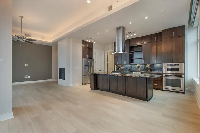 a large kitchen with a large counter top stainless steel appliances and cabinets