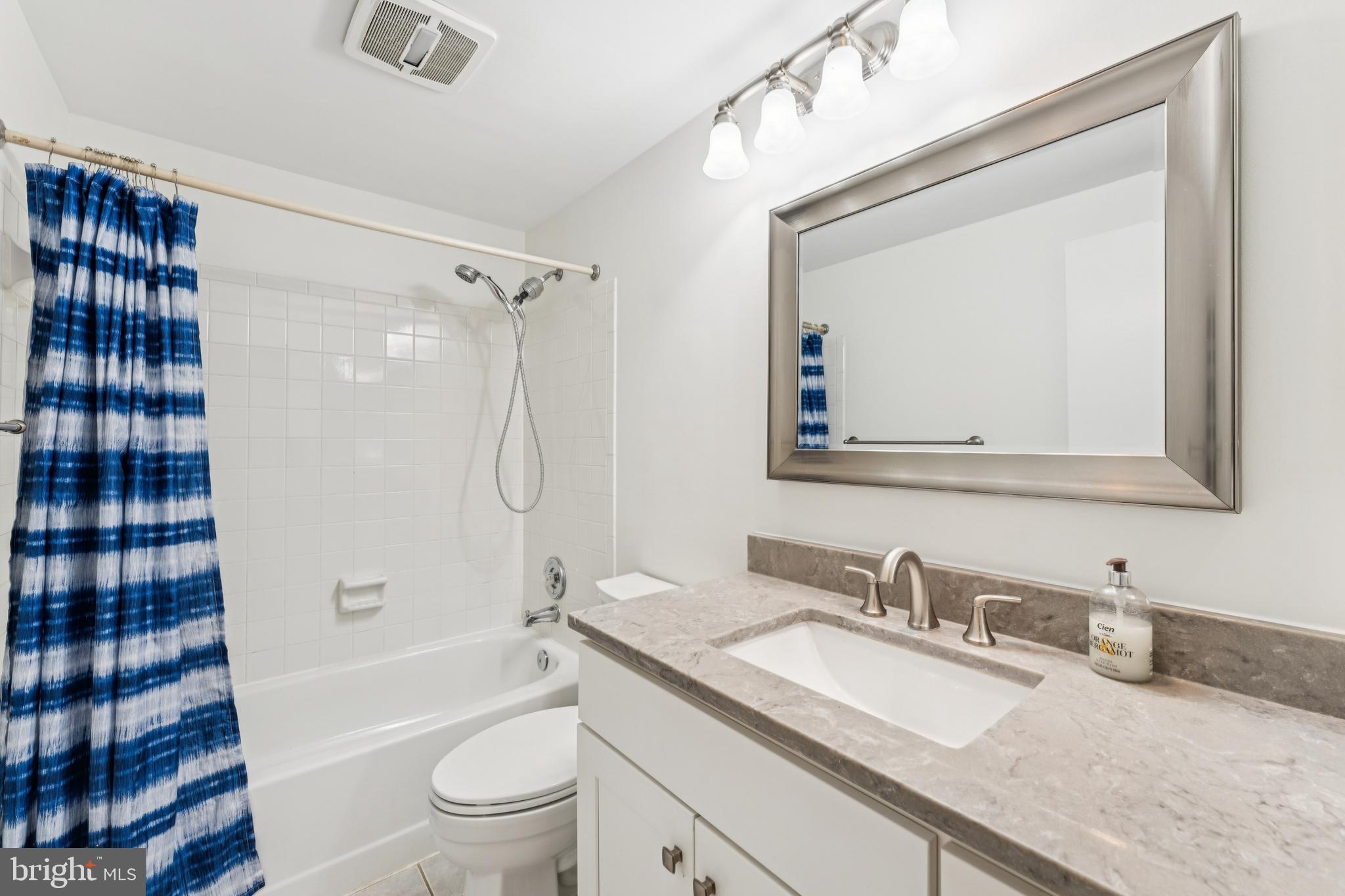 3152 B Covewood Court Falls Church, VA 22042 - Photo 12 of 26 a bathroom with a granite countertop sink toilet a mirror a vanity and shower