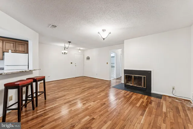 a view of empty room with wooden floor and fireplace