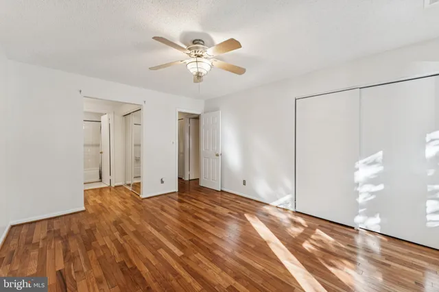 a view of an empty room and chandelier fan