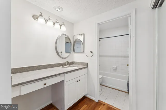 a en suite bathroom with a granite countertop sink and a mirror