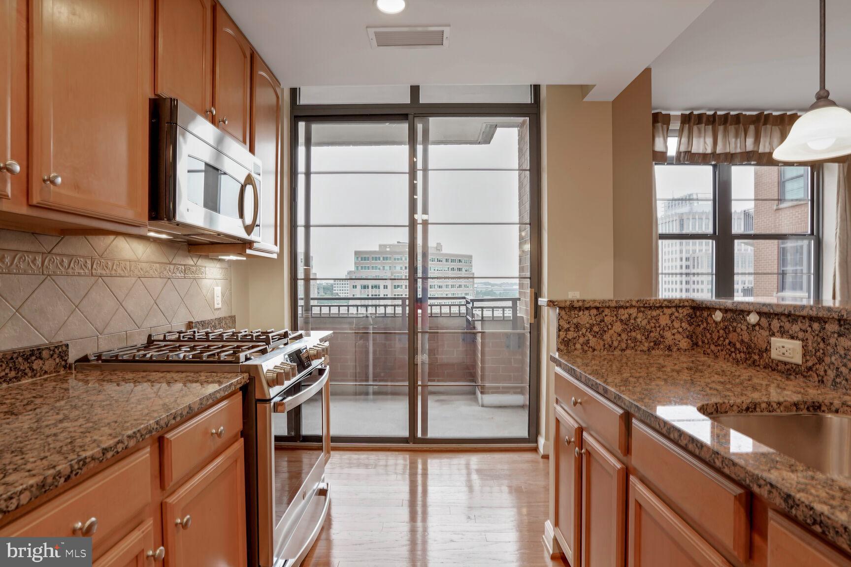 1830 Fountain Drive, Unit 1106 Reston, VA 20190 - Photo 25 of 30 a kitchen with stainless steel appliances granite countertop a stove a sink and a granite counter tops