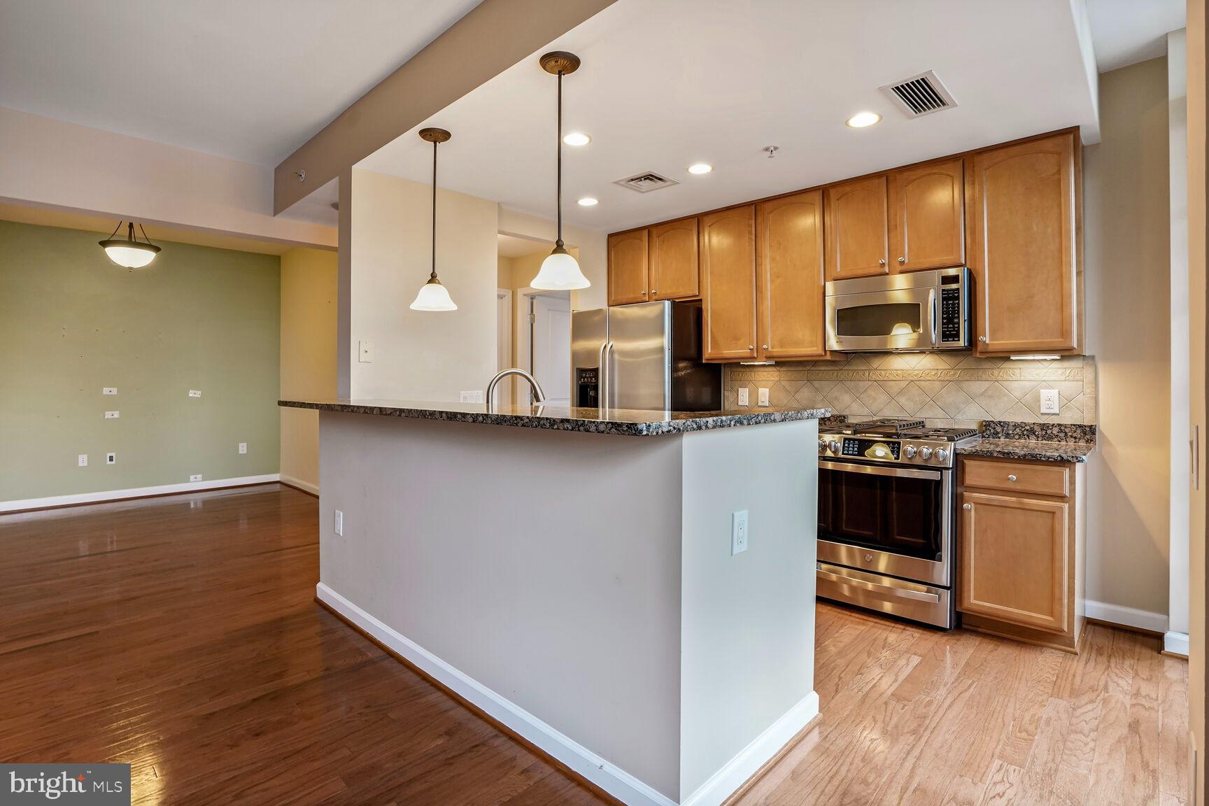 1830 Fountain Drive, Unit 1106 Reston, VA 20190 - Photo 6 of 30 a kitchen with stainless steel appliances granite countertop a stove a sink and a refrigerator