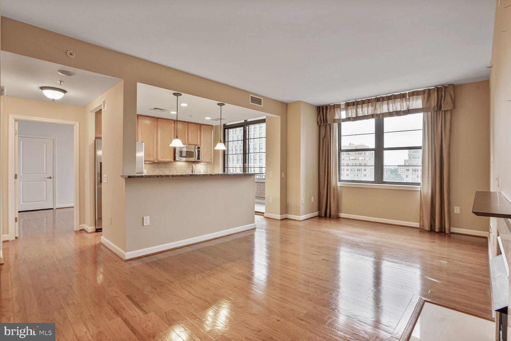 1830 Fountain Drive, Unit 1106 Reston, VA 20190 - Photo 8 of 30 an empty room with wooden floor and windows