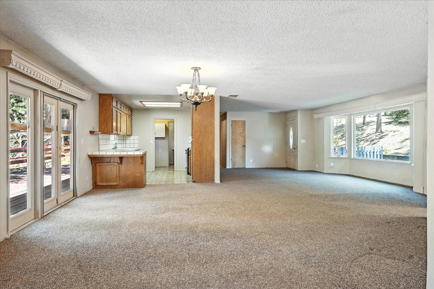 5783 Chowchilla Mountain Road Mariposa, CA 95338 - Photo 12 of 43 a view of a kitchen with furniture and a chandelier