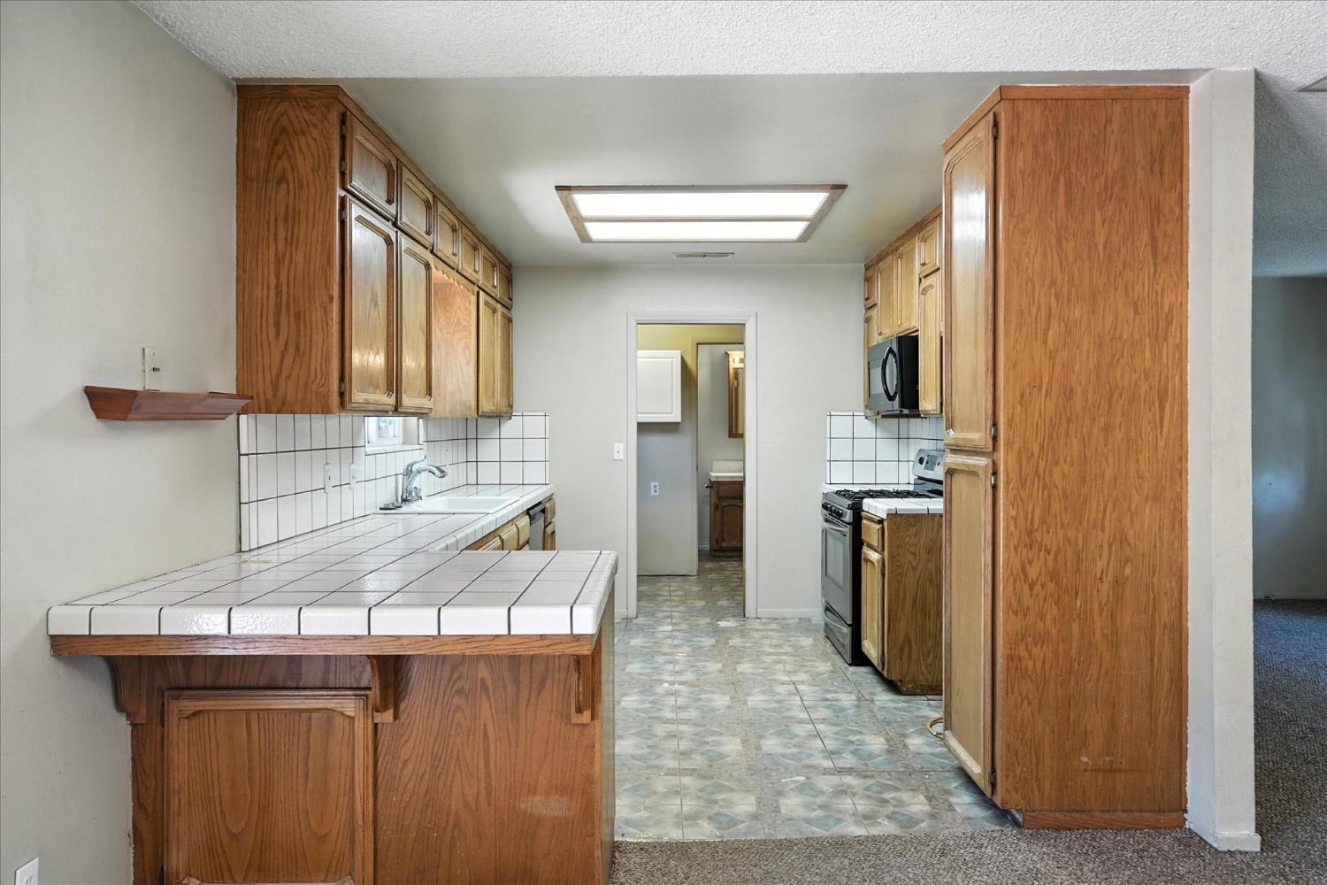5783 Chowchilla Mountain Road Mariposa, CA 95338 - Photo 15 of 43 a kitchen with a sink a refrigerator and cabinets