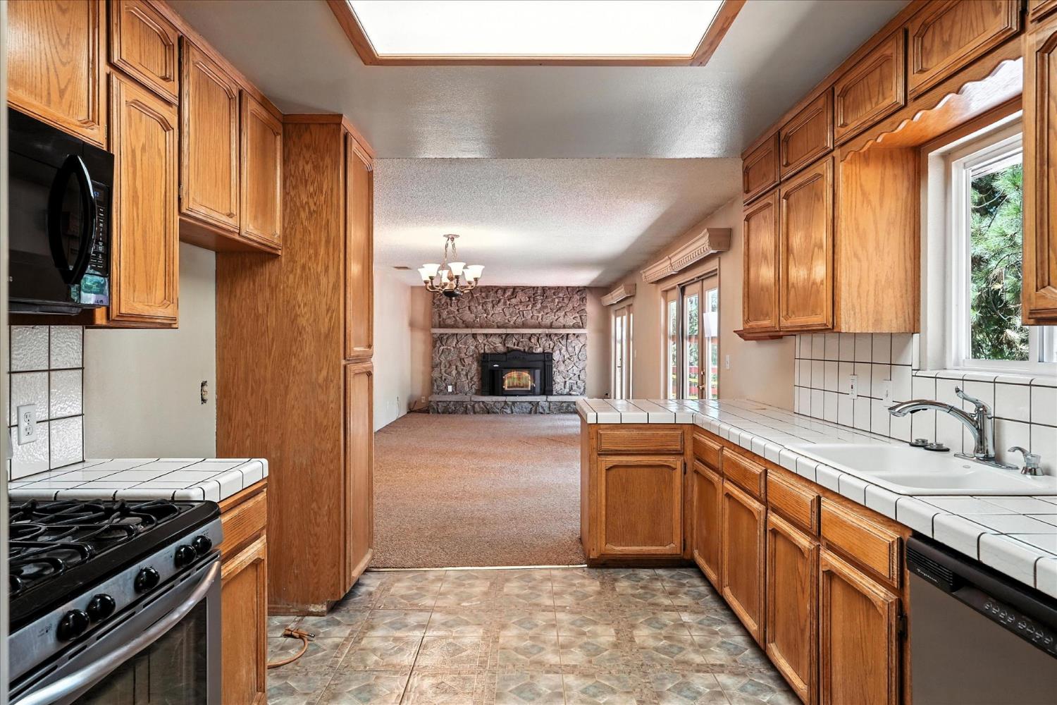 5783 Chowchilla Mountain Road Mariposa, CA 95338 - Photo 18 of 43 a kitchen with granite countertop a sink stove and refrigerator