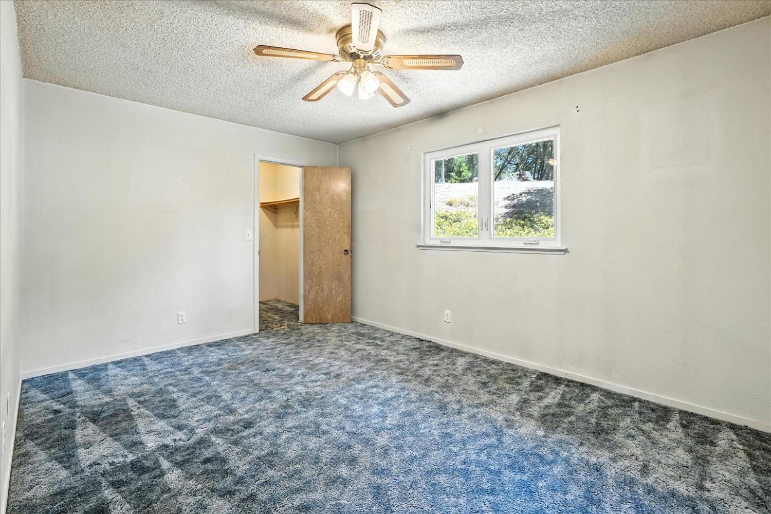 5783 Chowchilla Mountain Road Mariposa, CA 95338 - Photo 32 of 43 an empty room with windows and fan