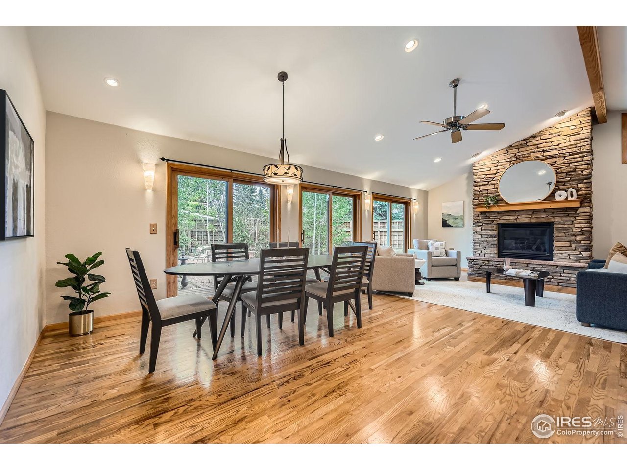5604 Bowron Place Longmont, CO 80503 - Photo 8 of 37 a view of a dining room and livingroom with furniture wooden floor a chandelier