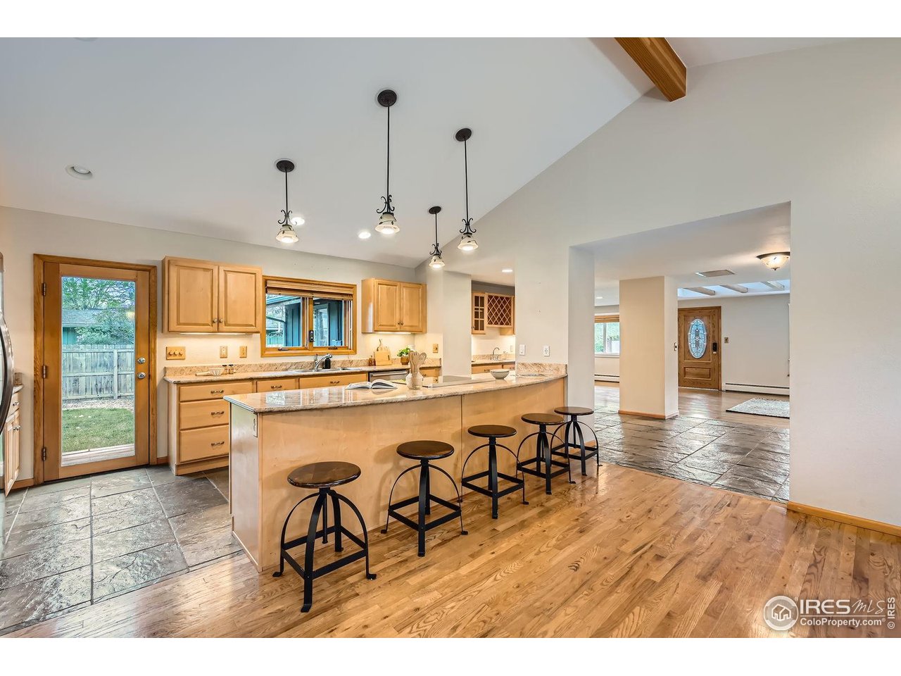 5604 Bowron Place Longmont, CO 80503 - Photo 9 of 37 a dining hall with stainless steel appliances kitchen island granite countertop a sink and cabinets