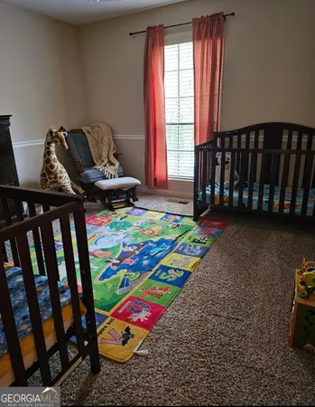 a bed sitting in a bedroom next to a window and a mirror