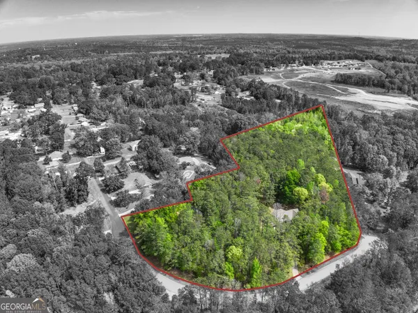 an aerial view of residential houses with outdoor space and trees