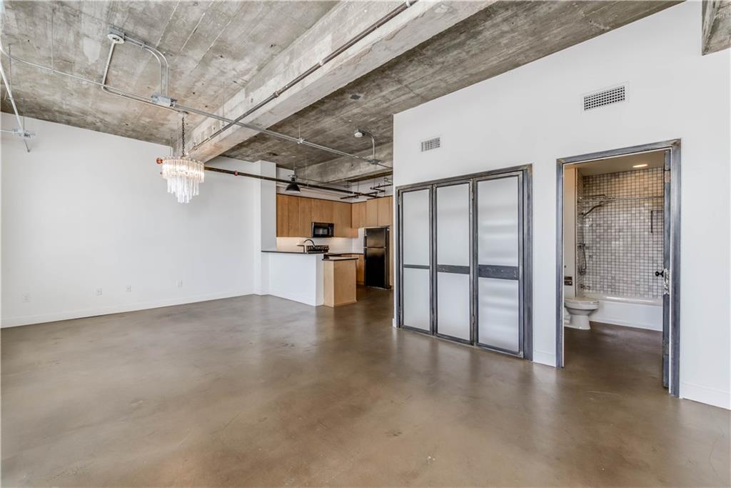 710 Colorado Street, Unit G9 Austin, TX 78701 - Photo 13 of 25 Open-concept living space with concrete floors and exposed industrial ceilings create an urban loft feel.