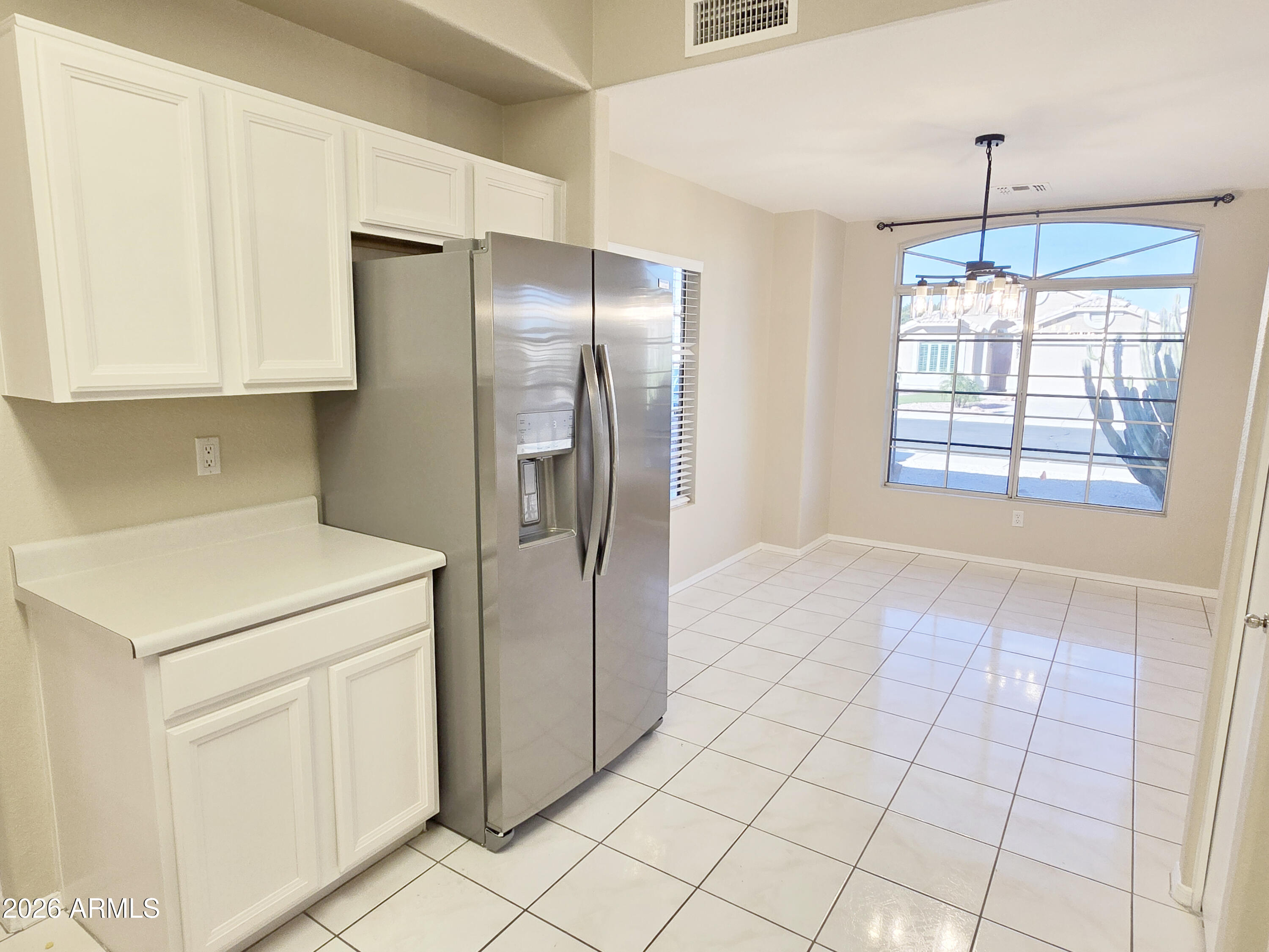 697 West Golden Street Gilbert, AZ 85233 - Photo 7 of 33 a kitchen with white cabinets and refrigerator