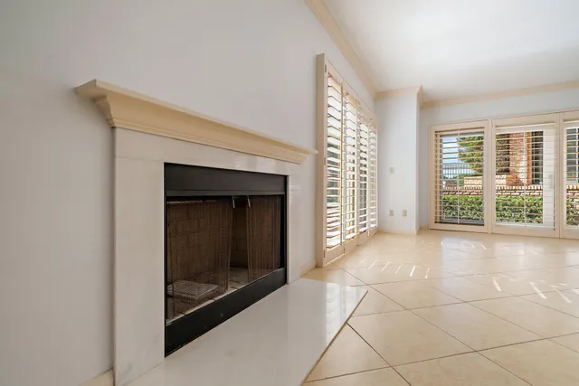 a view of an empty room with a fireplace and a window