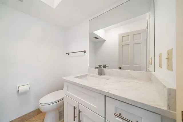 a bathroom with a sink toilet and a mirror