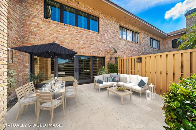 a view of a patio with couches table and chairs and potted plants
