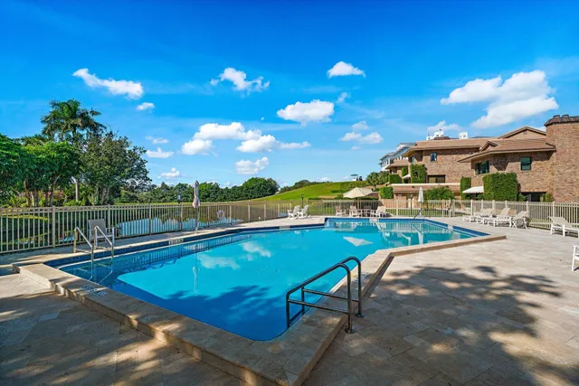 a view of a swimming pool with a patio and a yard