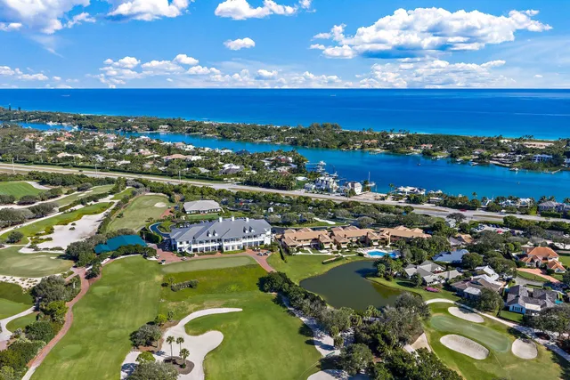 an aerial view of ocean and residential houses with outdoor space