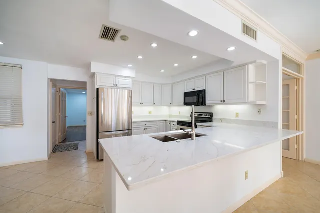 a kitchen with stainless steel appliances granite countertop a refrigerator and a sink