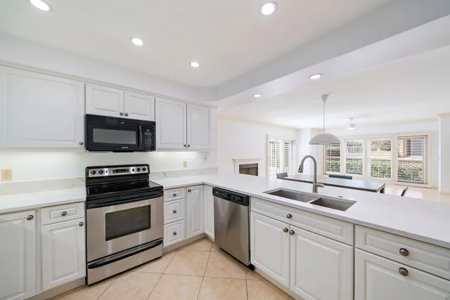 a kitchen with granite countertop white cabinets and white stainless steel appliances