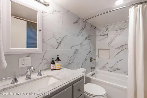 a bathroom with a sink toilet vanity and shower