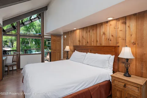 a bed sitting in a spacious bedroom next to a window