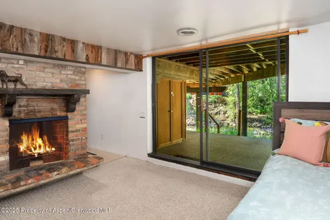 a living room with a fireplace and a floor to ceiling window