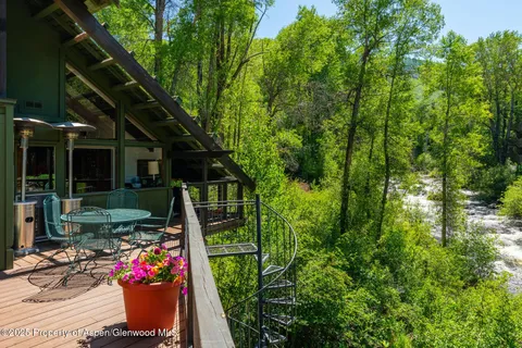 a view of a patio with table and chairs potted plants and large tree