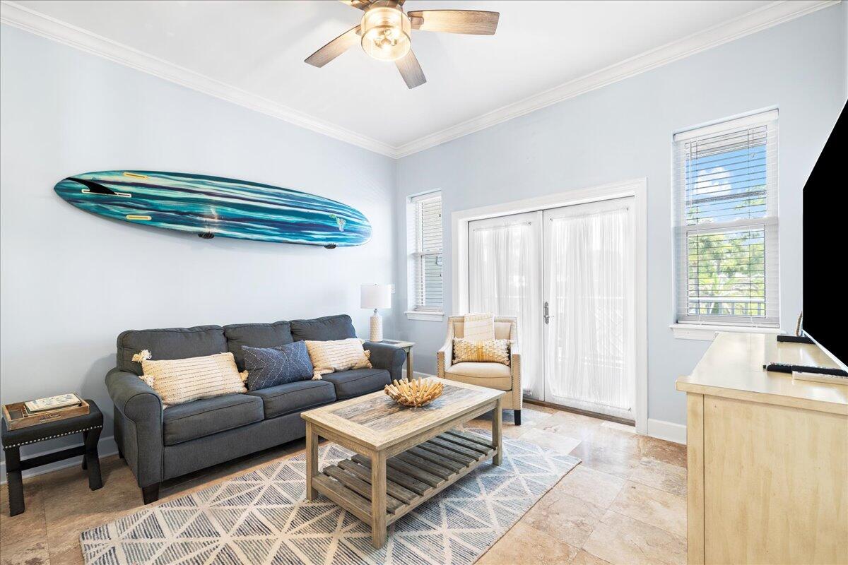a living room with furniture a ceiling fan and a window