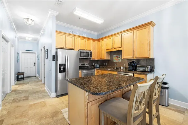 a kitchen with a refrigerator a stove top oven a sink and dining table