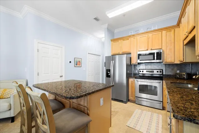 a kitchen with stainless steel appliances granite countertop a stove refrigerator and a microwave