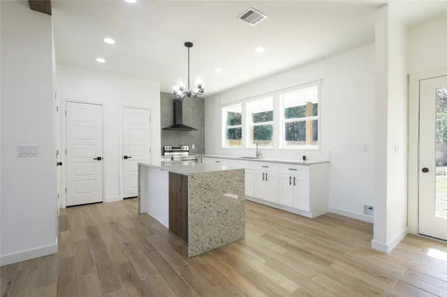 a kitchen with a sink cabinets and wooden floor