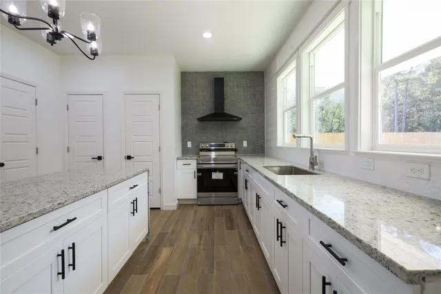a large kitchen with granite countertop a stove and a sink