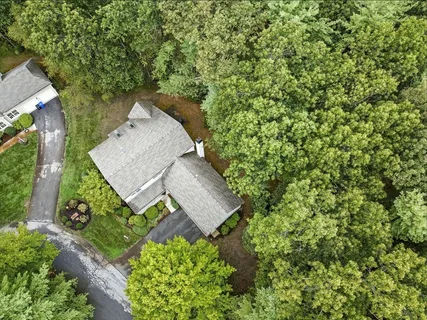 an aerial view of a house with a yard and large trees