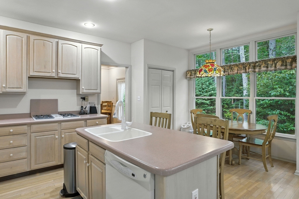 7 Alder Way, Unit 7 Bedford, MA 01730 - Photo 3 of 30 a kitchen with a stove a sink a center island and windows