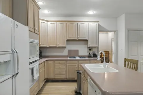 a kitchen with a sink a stove a refrigerator and cabinets