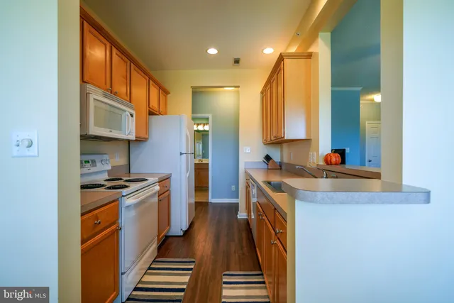 a kitchen with stainless steel appliances granite countertop a sink a stove and a refrigerator