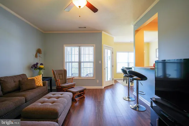 a living room with furniture a flat screen tv and a large window