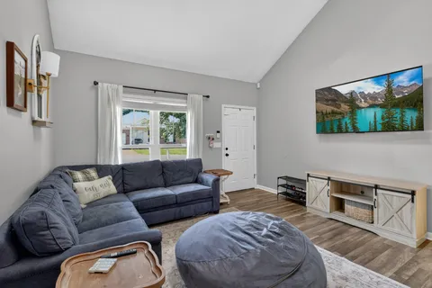 a living room with furniture a flat screen tv and a window