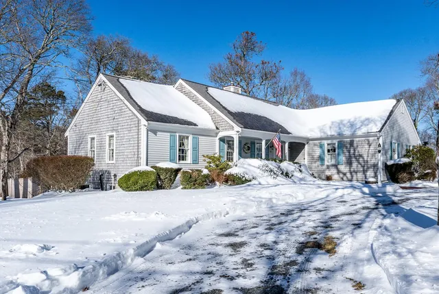 a view of a house with a yard covered in snow