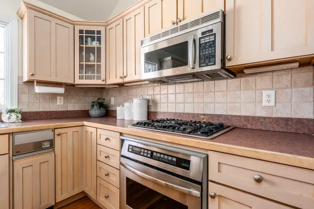 a kitchen with stainless steel appliances granite countertop a stove a sink and a microwave