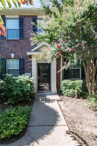 a front view of a house with a yard and potted plants