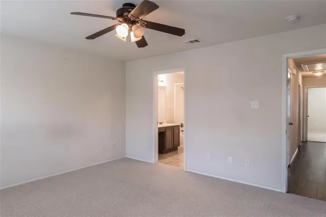 an empty room with closet and a chandelier fan