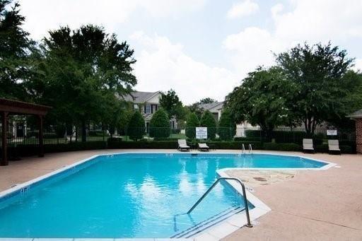 4074 Kyndra Circle Richardson, TX 75082 - Photo 26 of 27 a view of a swimming pool with lawn chairs under an umbrella